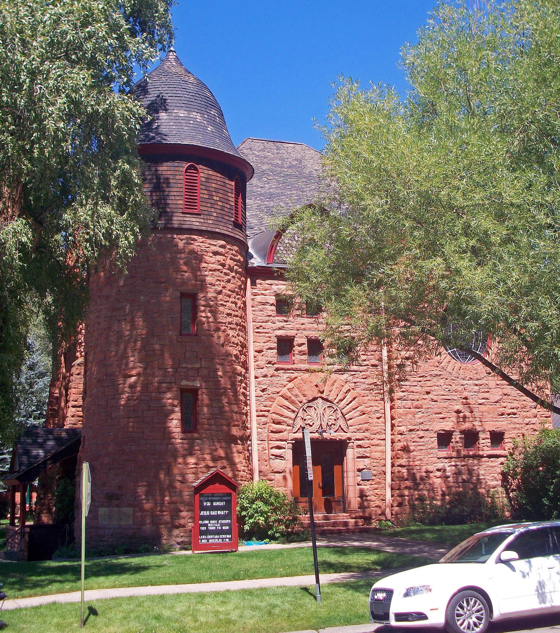 Aspen historic sandstone church with bell tower and Romanesque arches